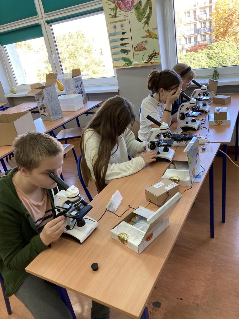 Uczniowie pracujący przy mikroskopach