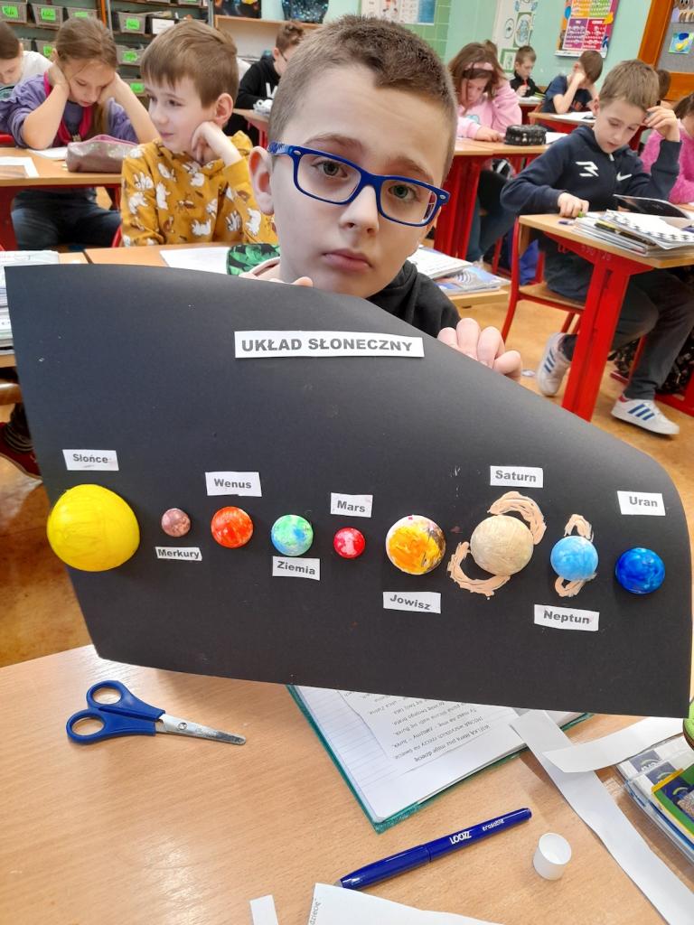 Uczeń prezentujący układ słoneczny