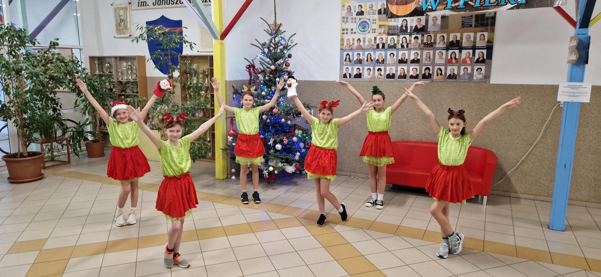 Dzieci stoją na tle choinki