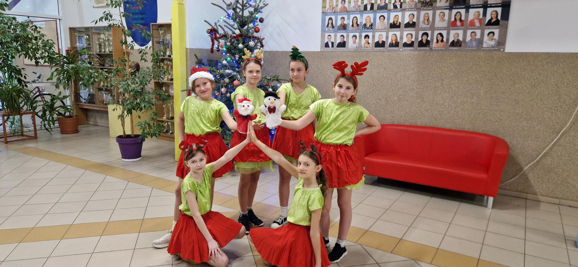 uczennice w strojach świątecznych na tle choinki