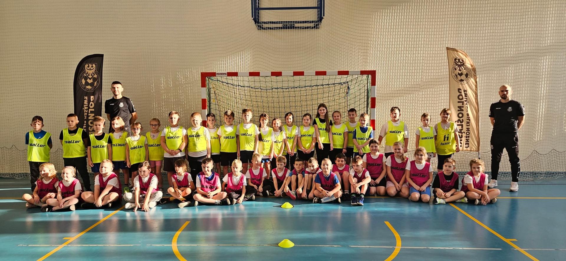 Grupa dzieci stoji na tle bramki