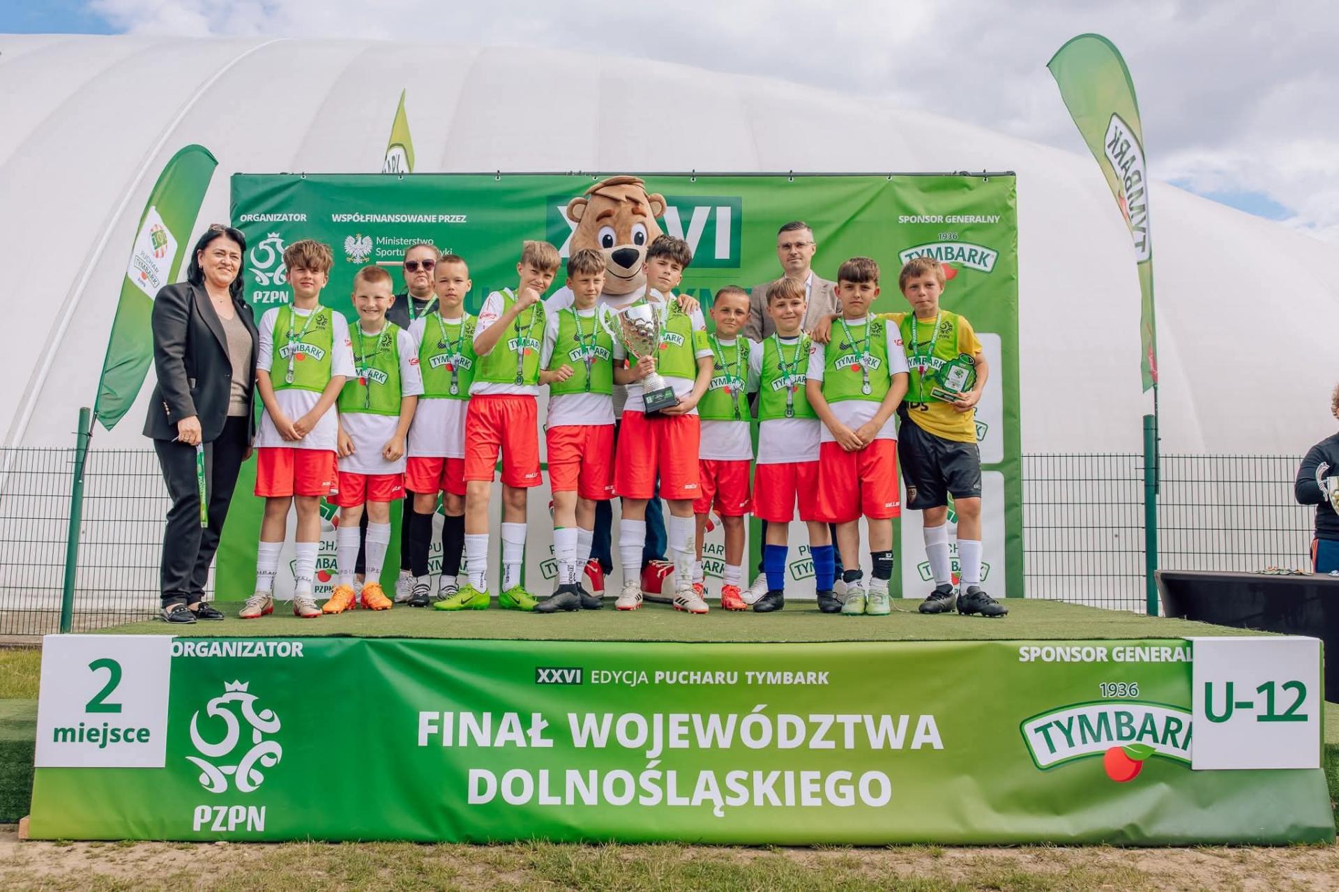 drużyna chłpoców stoi na podium